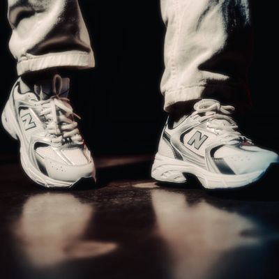 Close-up on athletic footwear on a clean studio floor.